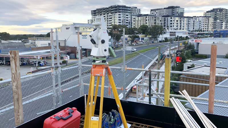 Total station on scaffolding — urban construction set-out